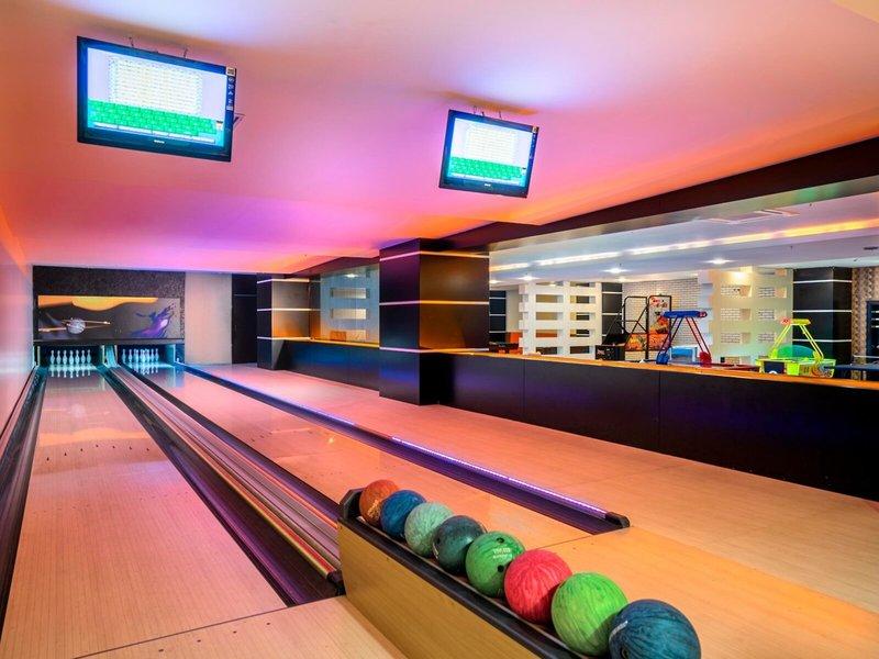 Bowlingbahn im Kirman Leodikya Resort Hotel mit bunten Lichtern und Bowlingkugeln.