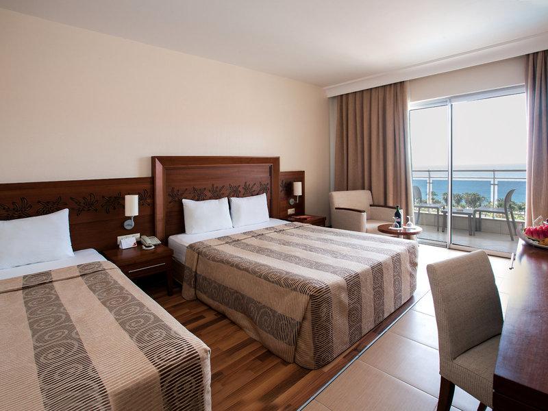Zimmer im Kirman Leodikya Resort mit zwei Betten, Balkon und Meerblick.
