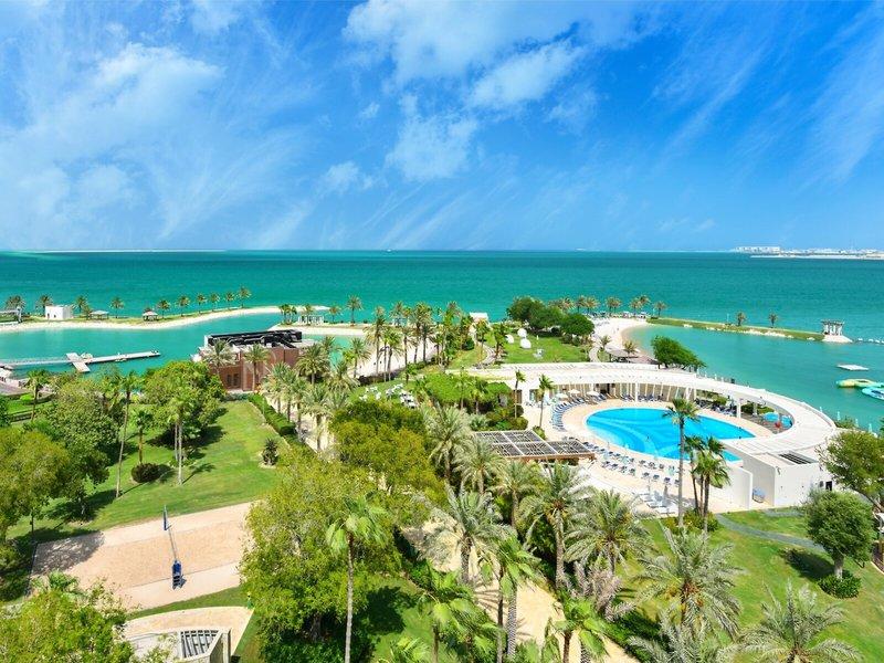Luftaufnahme des Sheraton Doha Resort Convention Hotel mit Meer, Pool und Palmen
