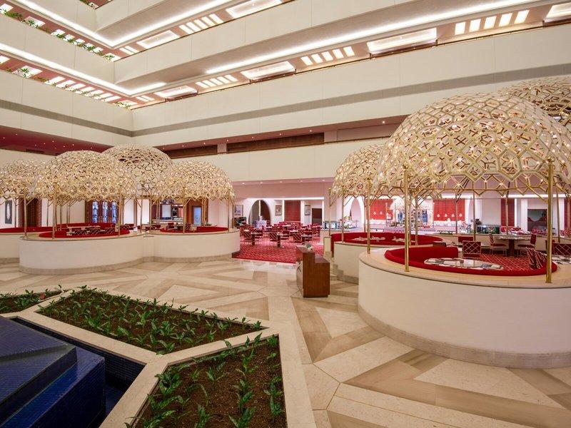 Innenbereich des Sheraton Doha Resort Convention Hotel mit modernen Sitzbereichen und goldenen Pavillons.