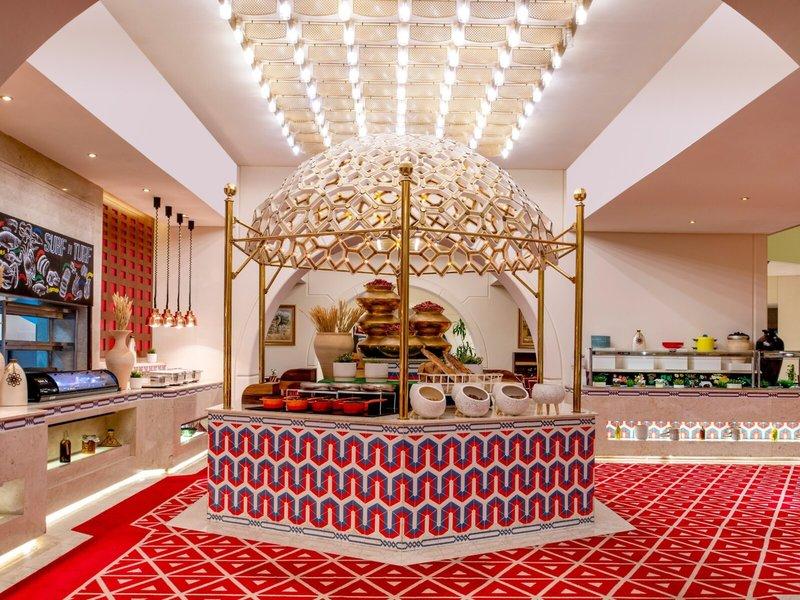 Innenbereich des Sheraton Doha Resort Convention Hotel mit einem goldenen Pavillon, rotem Teppich und geometrischen Mustern.