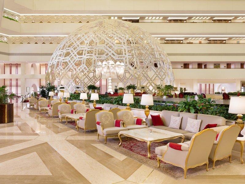 Lobby des Sheraton Doha Resort Convention Hotel mit großer strukturierter Decke und eleganten Möbeln.
