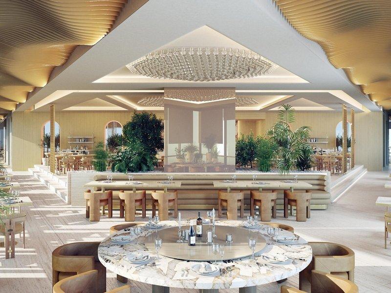 Innenbereich des Sheraton Doha Resort Convention Hotel mit Tisch, Stühlen und Pflanzen.