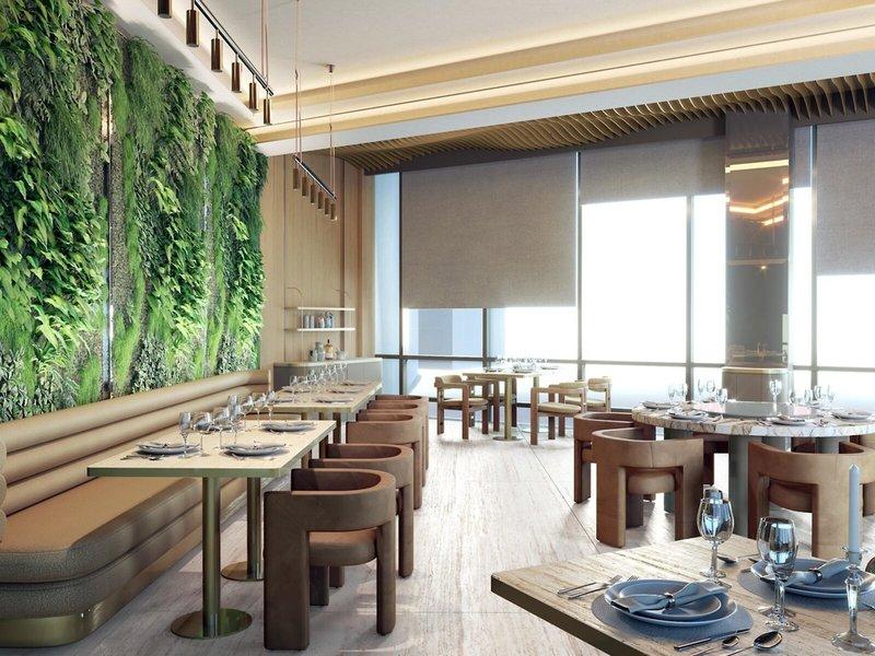 Innenansicht eines Restaurants im Sheraton Doha Resort Convention Hotel mit grüner vertikaler Begrünung und moderner Einrichtung.