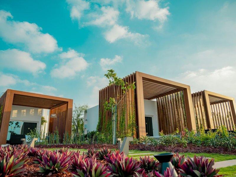 Außenbereich des Rixos Gulf Hotel Doha mit Holzstrukturen und Pflanzen