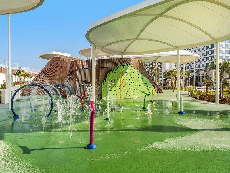 Wasserspielplatz im Rixos Gulf Hotel Doha mit bunten Wassersprudlern und Spielgeräten.
