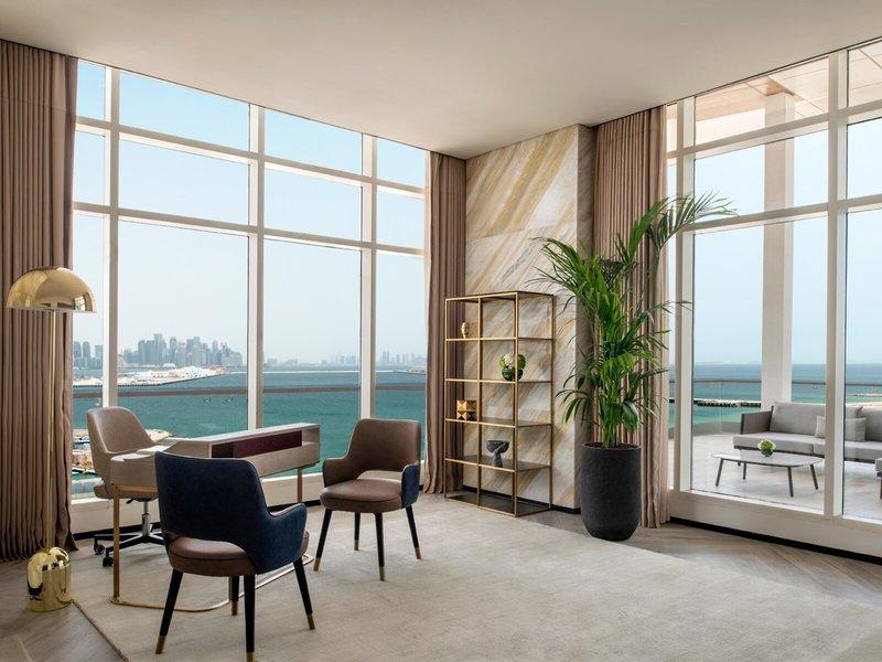 Innenraum des Rixos Gulf Hotel Doha mit Blick auf das Meer, Möbel und Pflanzen.