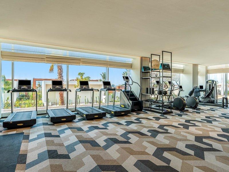 Fitnessstudio im Rixos Gulf Hotel Doha mit Laufbändern und anderen Geräten.