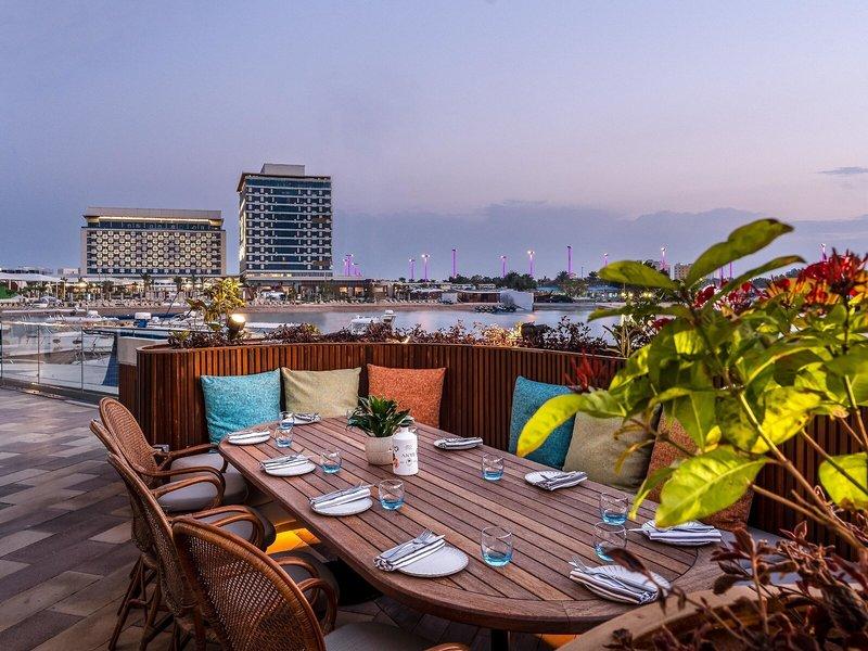 Abendessen auf der Dachterrasse des Rixos Gulf Hotel Doha mit Blick auf den Hafen.