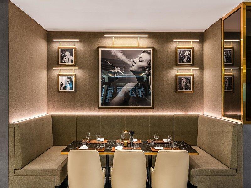 Innenraum des Rixos Gulf Hotel Doha mit einem großen Bild und vier kleineren Porträts an der Wand.