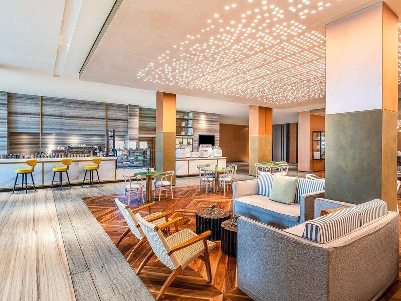 Rixos Gulf Hotel Doha Innenbereich mit Sitzbereichen und Bar.