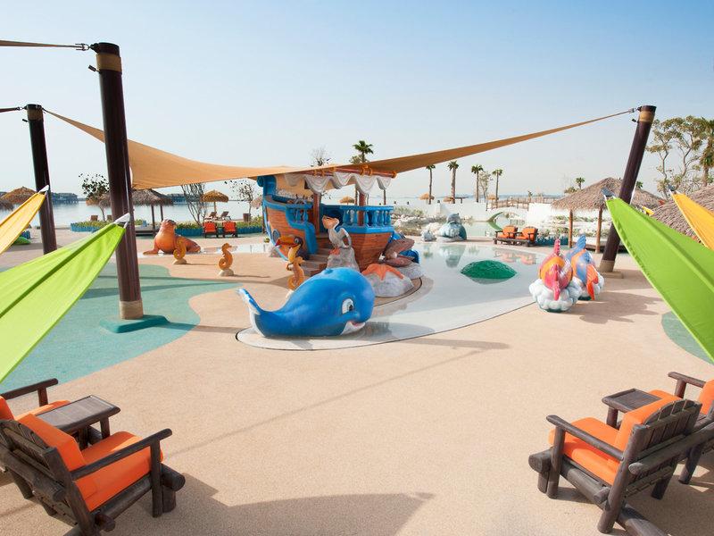 Kinderspielplatz im Banana Island Resort Doha von Anantara mit Wasserspielstation und bunten Figuren.