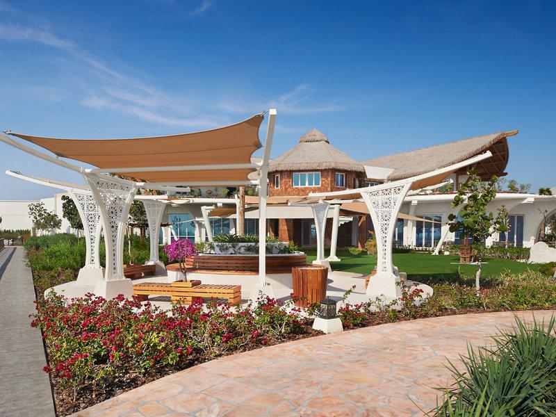 Außenbereich des Banana Island Resort Doha von Anantara mit Pavillon und Gebäude im Hintergrund