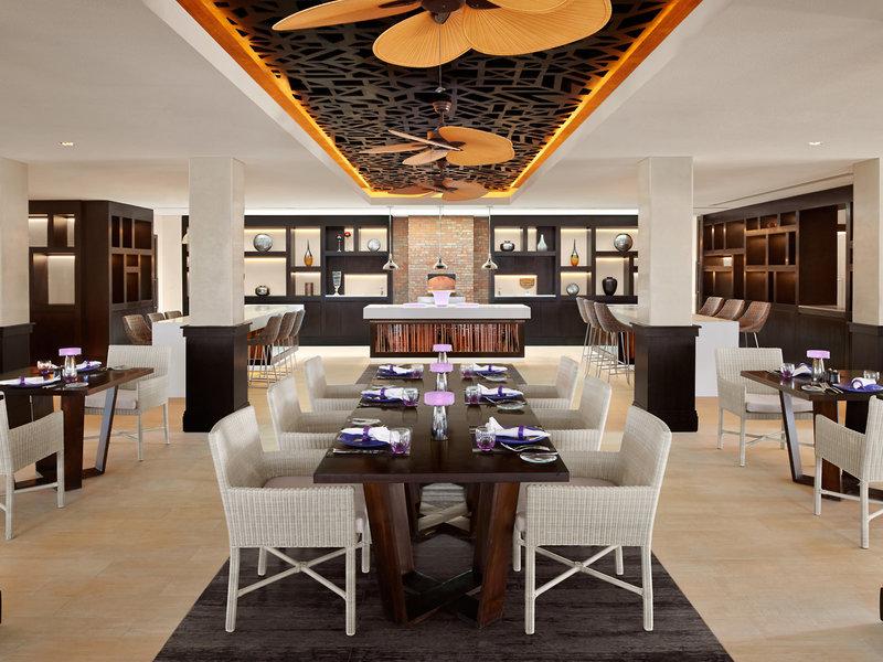 Innenansicht des Restaurants im Banana Island Resort Doha von Anantara mit langen Tisch, Stühlen und moderner Einrichtung.