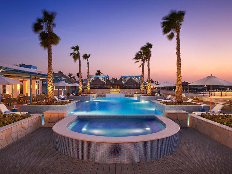 Außenpool des Banana Island Resorts Doha von Anantara bei Nacht