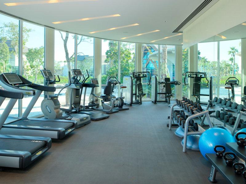Fitnessstudio im Banana Island Resort Doha mit Laufbändern und Hanteln.