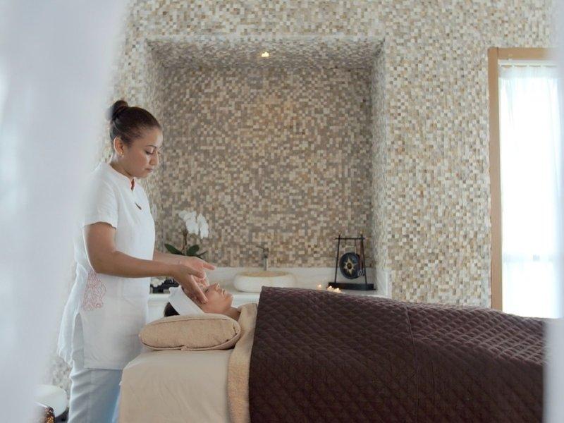 Eine Frau, die eine Gesichtsmassage in einem Spa im Banana Island Resort durchführt.