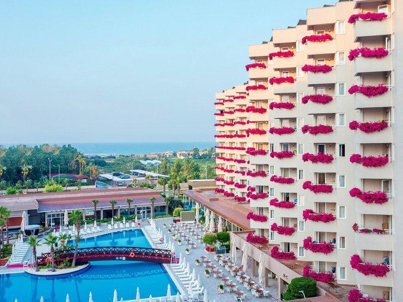 Grand Park Lara Hotel Außenansicht mit Swimmingpool und roten Blumen an den Balkonen