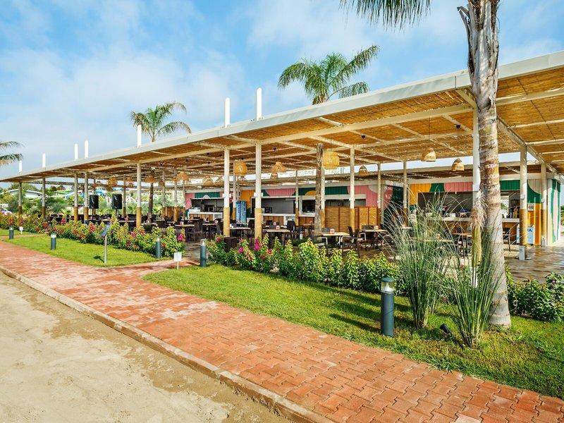 Außenbereich des Grand Park Lara Restaurants mit Tischen und Stühlen unter einem Dach.