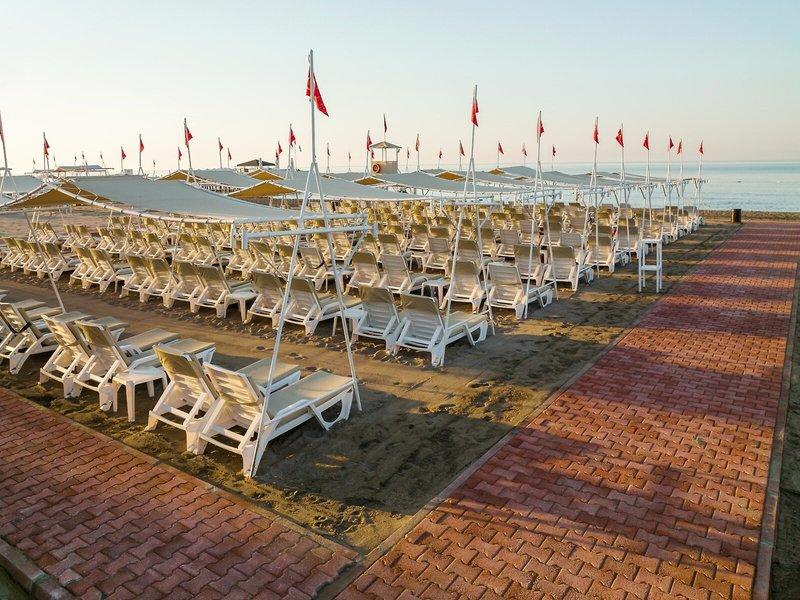 Strandbereich des Grand Park Lara Hotels mit vielen Sonnenliegen und Sonnenschirmen