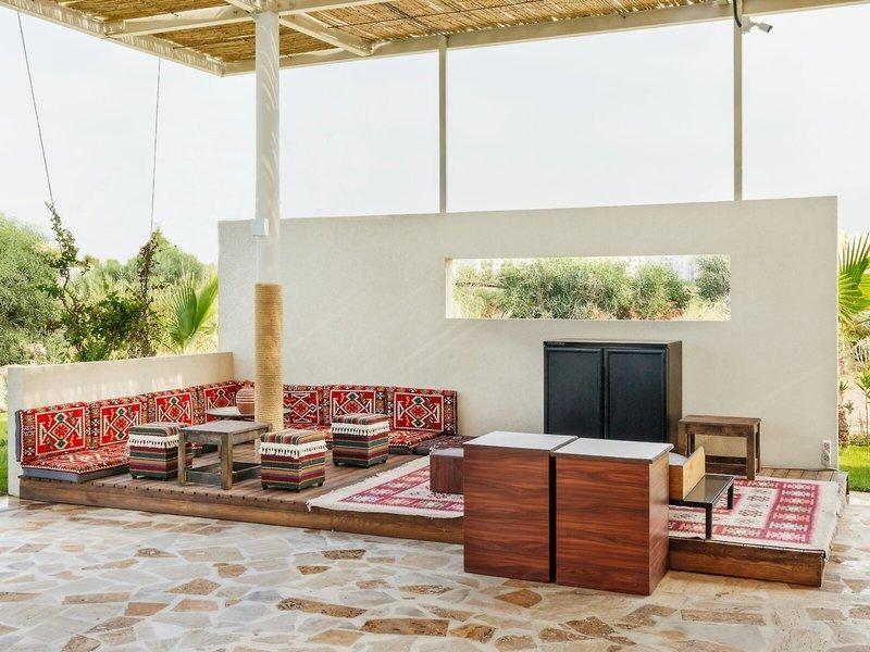 Außenbereich des Grand Park Lara Hotels mit Loungemöbeln und Teppichen.