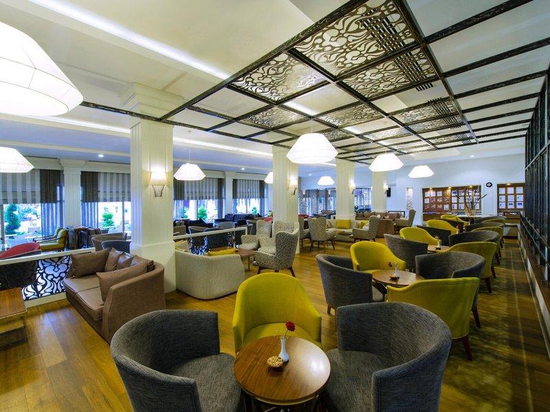 Innenansicht des Grand Park Lara Hotel-Loungebereichs mit vielen Stühlen und Tischen.