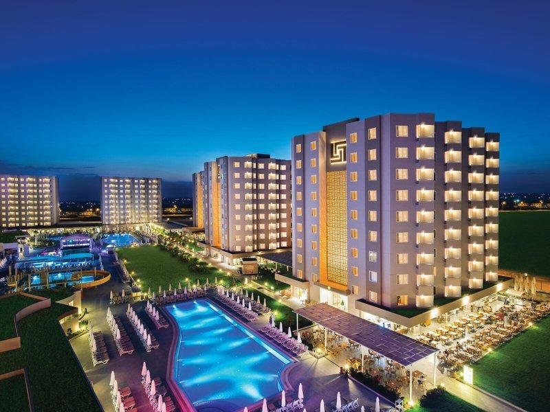 Grand Park Lara Hotel bei Nacht mit beleuchteten Gebäuden und Swimmingpool