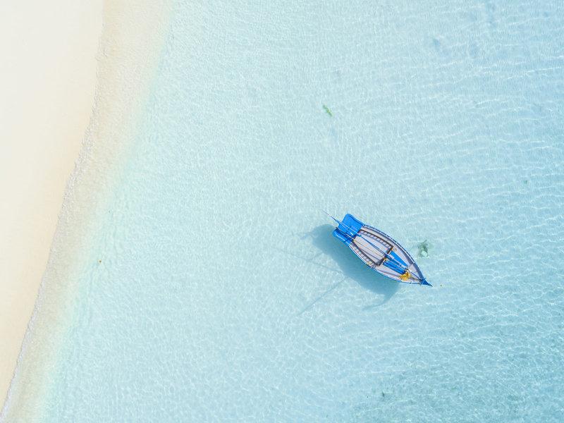 Luftaufnahme eines Bootes im klaren Wasser in der Nähe eines Strandes
