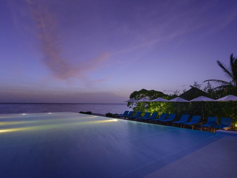 Infinity-Pool des Summer Island Maldives Hotels bei Nacht mit Blick auf den Ozean