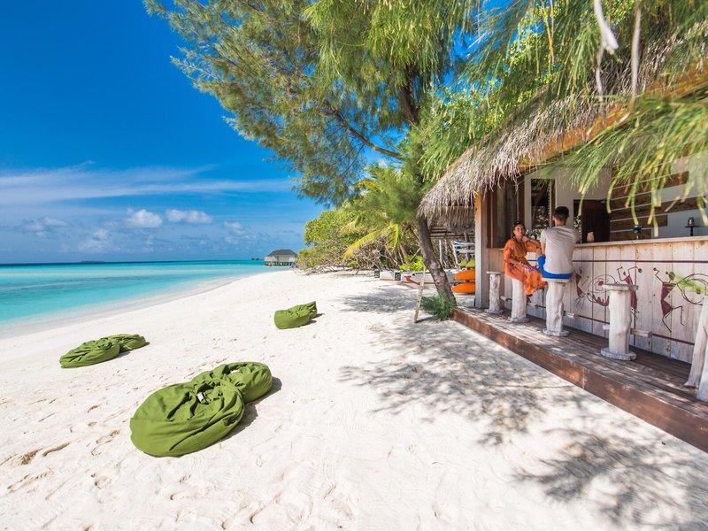 Strandbar des Summer Island Maldives Hotels mit zwei Gästen und Blick auf den Strand