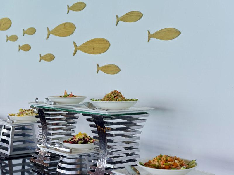 Buffet im Sommer Island Maldives mit verschiedenen Salaten auf Glastischen.