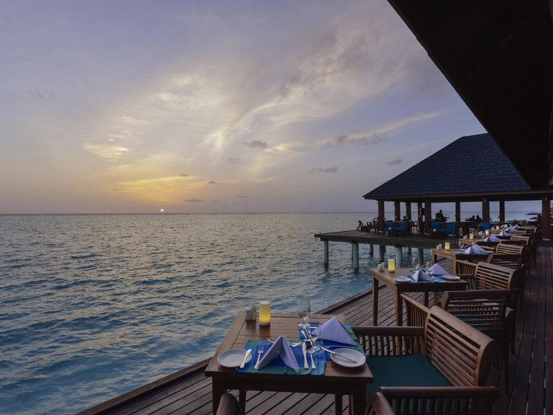 Terrasse des Summer Island Maldives Hotels bei Sonnenuntergang mit Blick aufs Meer