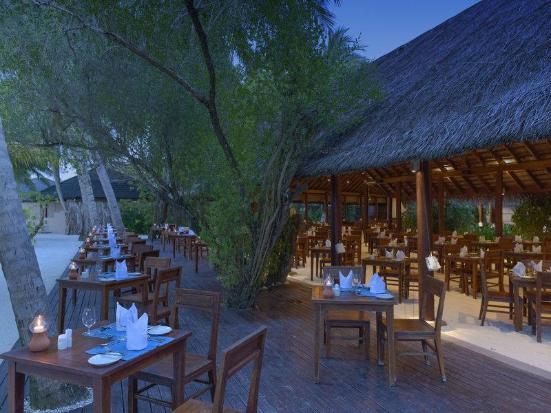 Außenbereich des Restaurants im Summer Island Maldives Hotel mit gedeckten Tischen und abendlicher Atmosphäre.