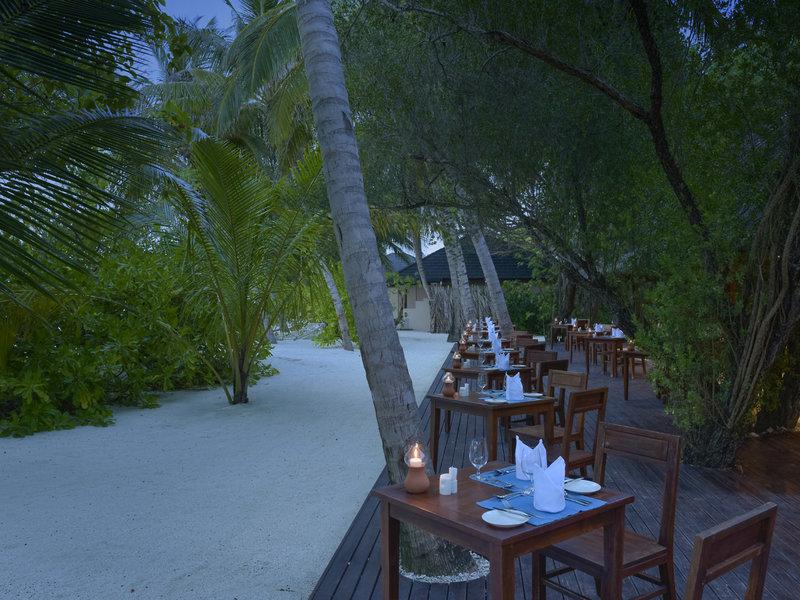 Abendessen auf der Terrasse im Summer Island Maldives Hotel bei Nacht mit brennenden Kerzen.