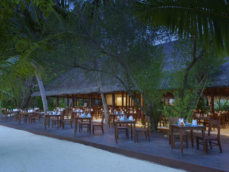 Alfresco-Essbereich im Summer Island Maldives Hotel mit Tischen und Stühlen im Freien.