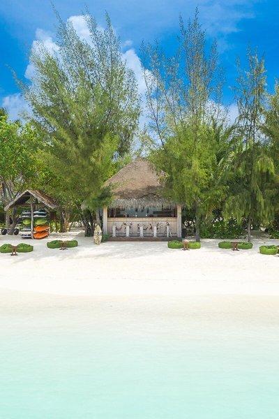 Strandansicht des Summer Island Maldives Hotels mit einer Bar und Wassersportgeräten.