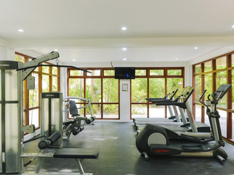 Fitnessstudio im Summer Island Maldives Hotel mit Fenstern und Trainingsgeräten.