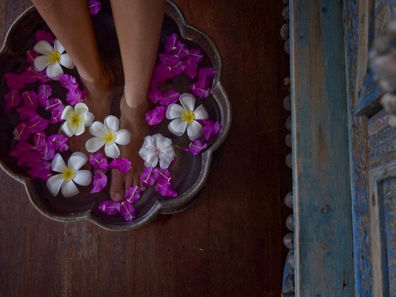Füße in einem Blumenbad im Hotel Summer Island Maldives