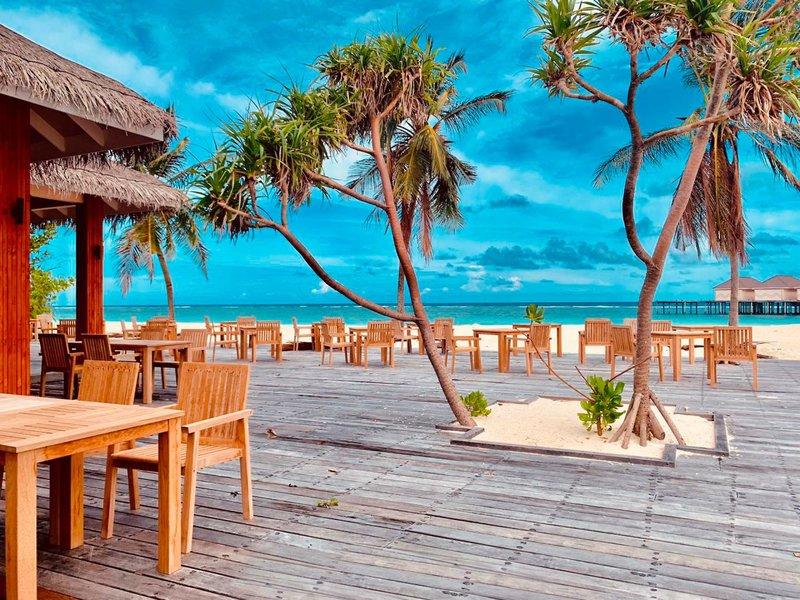 Restaurant mit Tischen und Stühlen auf der Strandterrasse im Brennia Kottefaru Maldives