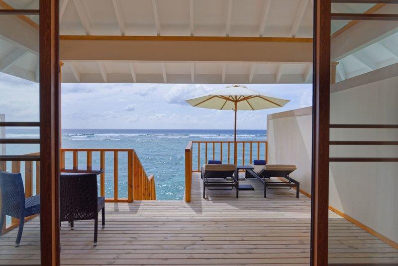 Terrasse des Brennia Kottefaru Maldives mit Blick auf das Meer und eine offene Tür.
