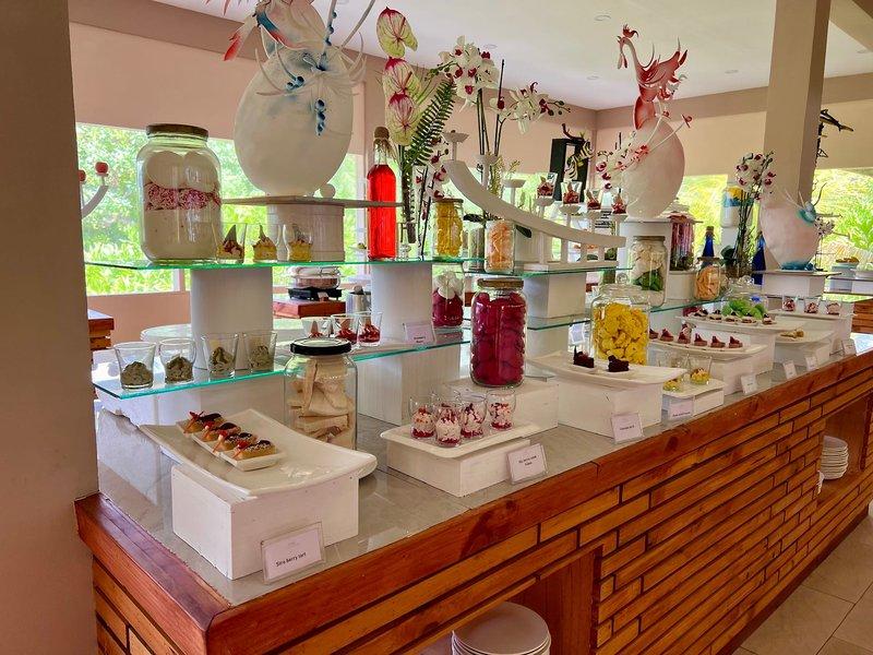 Buffet im Brennia Kottefaru Maldives mit verschiedenen Desserts und Getränken auf mehreren Etagen.