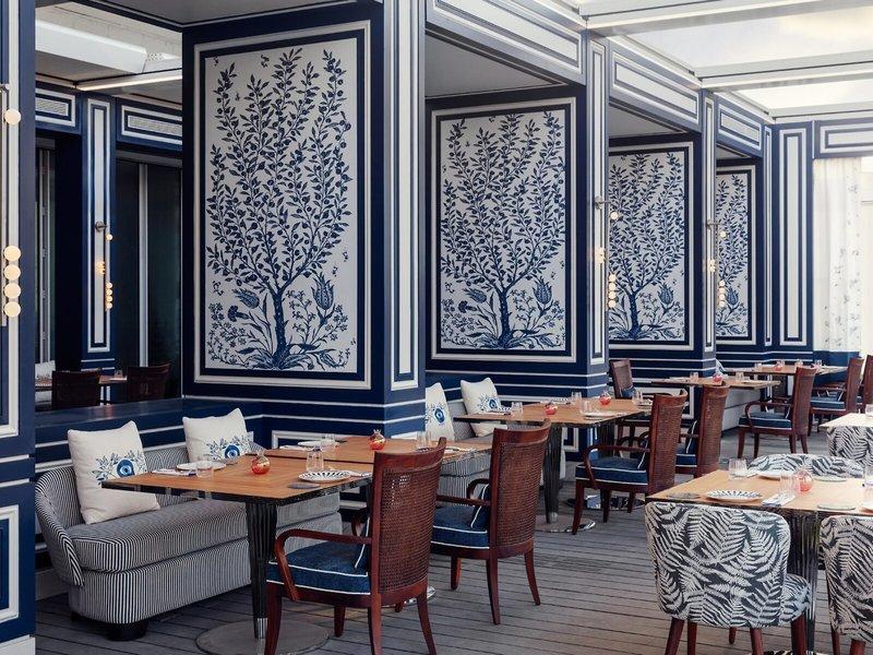 Interieur des Restaurants im St. Regis Al Mouj Muscat Resort mit blauen und weißen Wänden.
