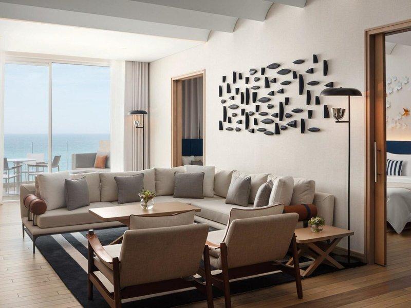 Wohnbereich im St. Regis Al Mouj Muscat Resort mit Meerblick und modernen Möbeln.
