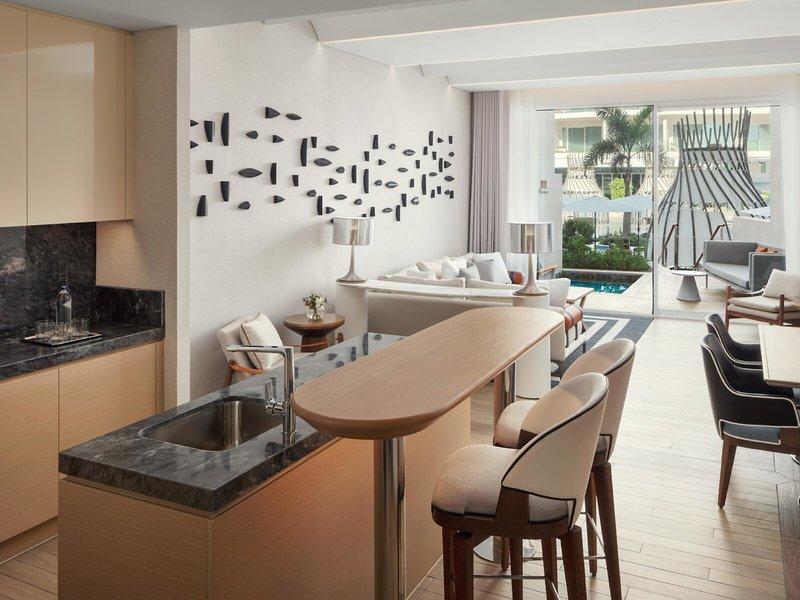 Wohnbereich im St. Regis Al Mouj Muscat Resort mit modernem Design, Sitzbereich und Küche.