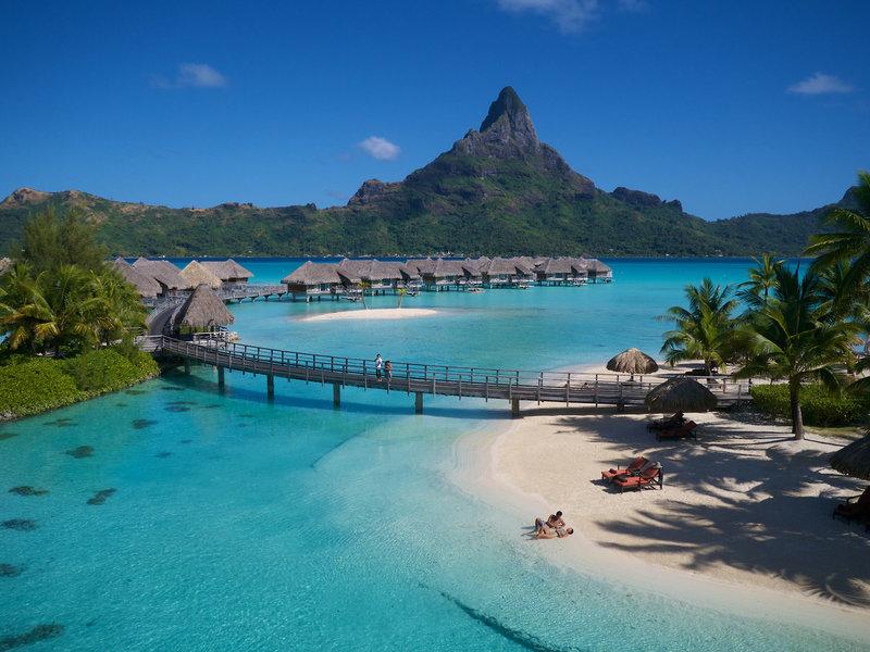 Luftaufnahme des InterContinental Bora Bora Resorts zeigt die Bungalows am Wasser und den Berg im Hintergrund.