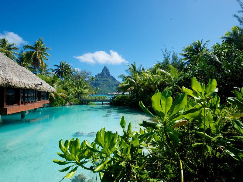 Das InterContinental Bora Bora Resort and Thalasso Spa mit einer Hütte am Wasser und einem Steg zur Insel.