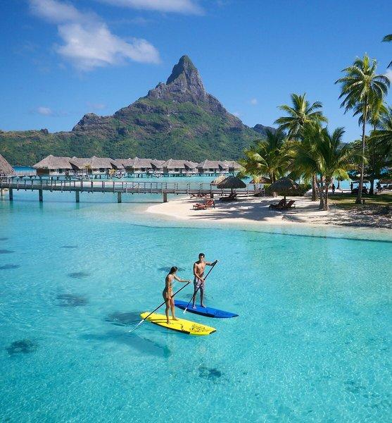 Zwei Leute auf Surfbrettern im Wasser vor der Insel Bora Bora