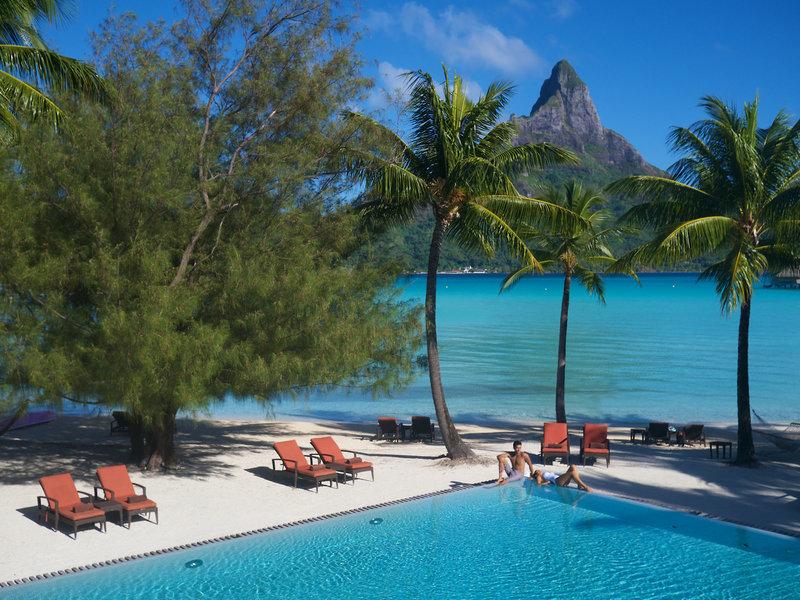 Poollandschaft des InterContinental Bora Bora Resort mit Blick auf den Berg und den Ozean.