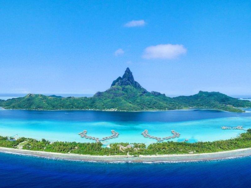 Luftaufnahme des InterContinental Bora Bora Resorts mit kristallklarem Wasser und grüner Insel.