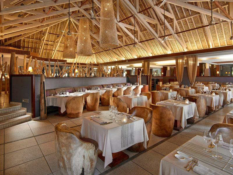 Innenbereich des Restaurants im InterContinental Bora Bora Resort and Thalasso Spa mit runden Holzstühlen und Tischen.